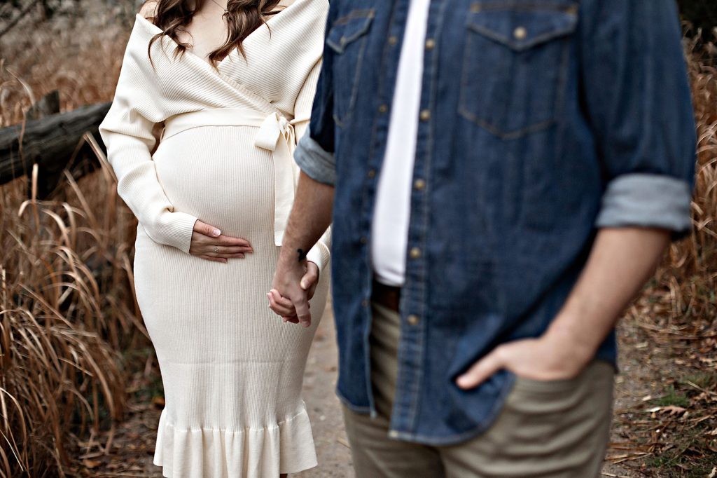 Pregnant woman with partner in autumn park